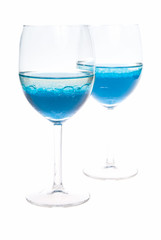 two glass with colored blue liquid on a white background