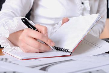 Fototapeta premium hand of a young business woman working with documents