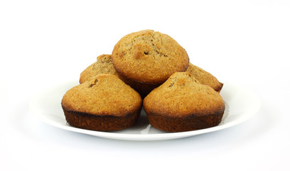 Freshly baked bran muffins on white plate