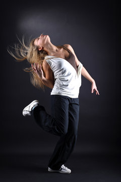 young woman modern dancer in action against black