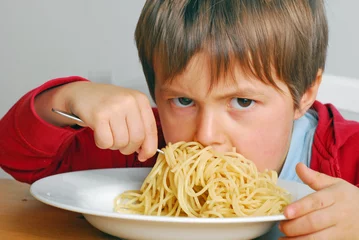 Fototapeten Trotziger Junge isst Nudeln © photophonie