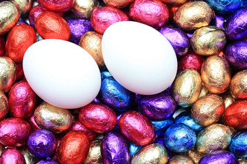 Chicken eggs on a group of chocolate easter eggs