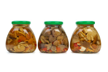 Three glass jars with marinated mushrooms