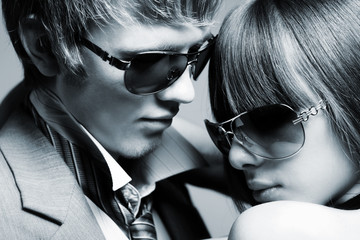 Fashionable young couple wearing sunglasses