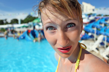 surprised woman standing in pool of an entertaining complex