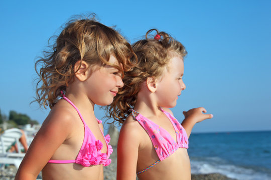 two pretty little girls on beach near sea, Looking afar