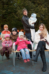 Man and girl with group of five children in autumn park