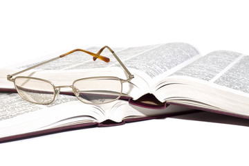 Pair of glasses on an open books