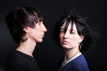 Cute young couple with fashion haircut, on black