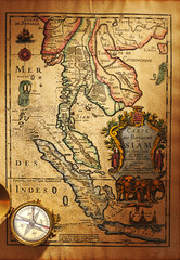 Fototapeta na wymiar Old brass compass over antique Thailand map
