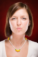 Portrait of beautiful woman sending kiss on red background