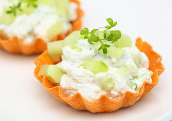 Close up tartlets filled with cream cheese, cucumber and green-H