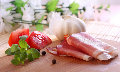 Prosciutto with tomatoes, garlic and basil (shallow focus)