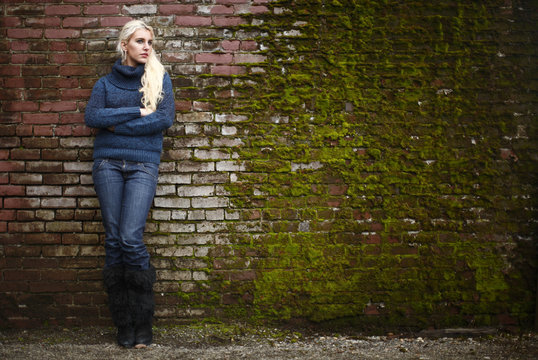 Young woman next to brickwall. - Powered by Adobe