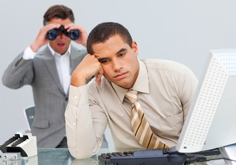 Angry businessman annoyed by a man looking through binoculars