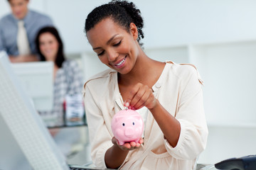 Positive businesswoman saving money in a piggy-bank