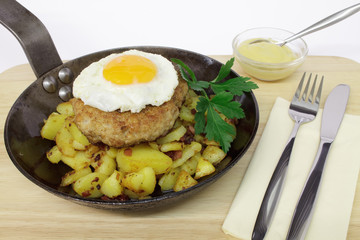 Frikadelle mit Spiegelei auf Bratkartoffeln