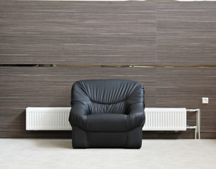 Alone black chair with radiator in minimalist interior