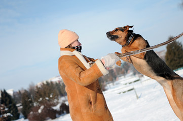 Happy girl jumping with dog against blue sky