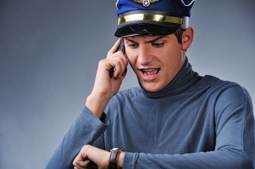 Handsome pilot talking on mobile phone