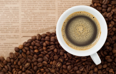 Cup and Coffee Beans on newspaper backgroun