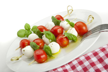 insalata caprese sticks on plate, tilted view