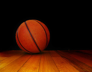 Obraz premium a basket ball on the court, over dark background