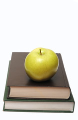 green apple on stack of book isolated