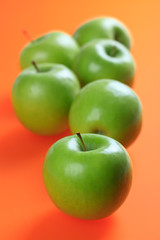 green apples on color background
