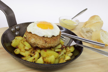 Frikadelle mit Spiegelei auf Bratkartoffeln