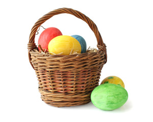 Painted Easter eggs in basket on white background