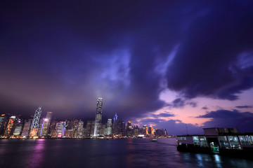Naklejka premium Hong Kong skyline at night, with dramatic sky.