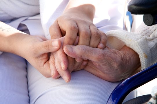 mains de personnel soignant assistant une personne agée