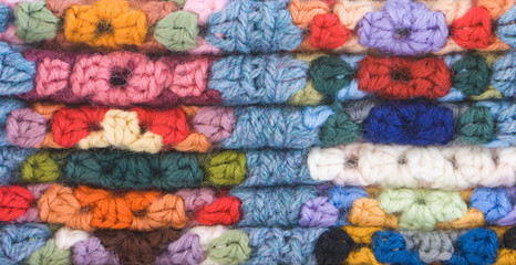 Close up macro shot of knitted crocheted squares, stacked.