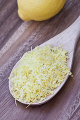 Wooden spoon filled with lemon zest.
