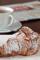 Croissant, tea and newspaper