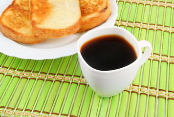 Fresh toasts and coffee cup on green background