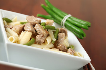 Penne rigate with pork, green beans and onion