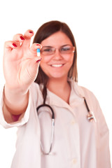 successful female doctor holding a pill in her hand