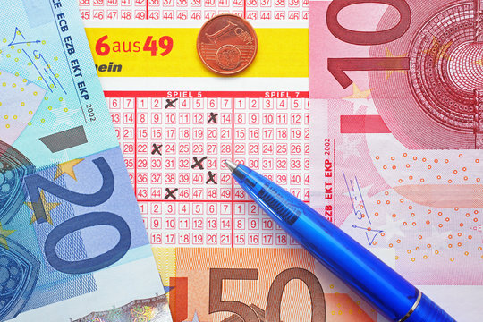Lottoschein mit Euros, Cent und Kugelschreiber