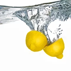 Foto op Canvas Verse citroen in water gevallen met bubbels geïsoleerd op wit © artjazz