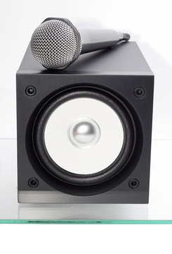 broadband speaker with microphone on the glass table.