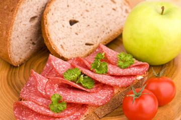 Belegtes Brot mit Salami mit Apfel und Tomate