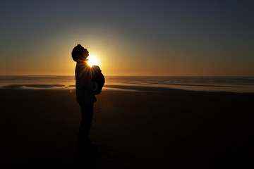 Mutter mit kind am Strand bei Sonnenuntergang