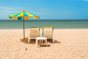 Beach with two sunbeds and umbrella