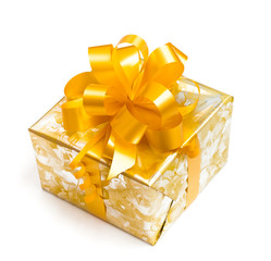 Nice gift packed in golden paper with yellow bow on white backgr