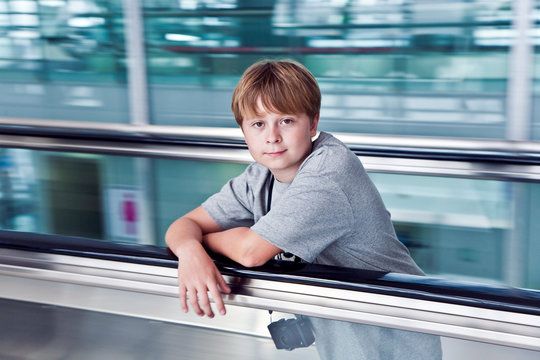 boy in departure hall  in the new Airport  on a moving staircase