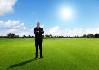 young businessman on green field