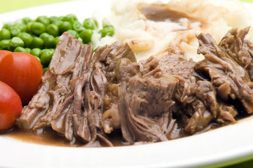 pot roast dinner with gravy mashed potatoes peas