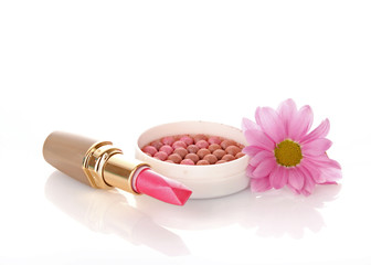 New lipstick and pink flower on white background